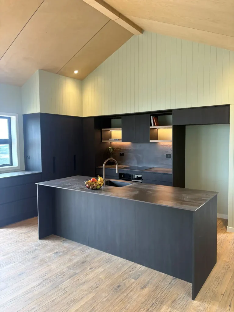 Paraparaumu Beach kitchen renovation featuring salt-resistant cabinetry, stone benchtop and indoor-outdoor flow to beach deck