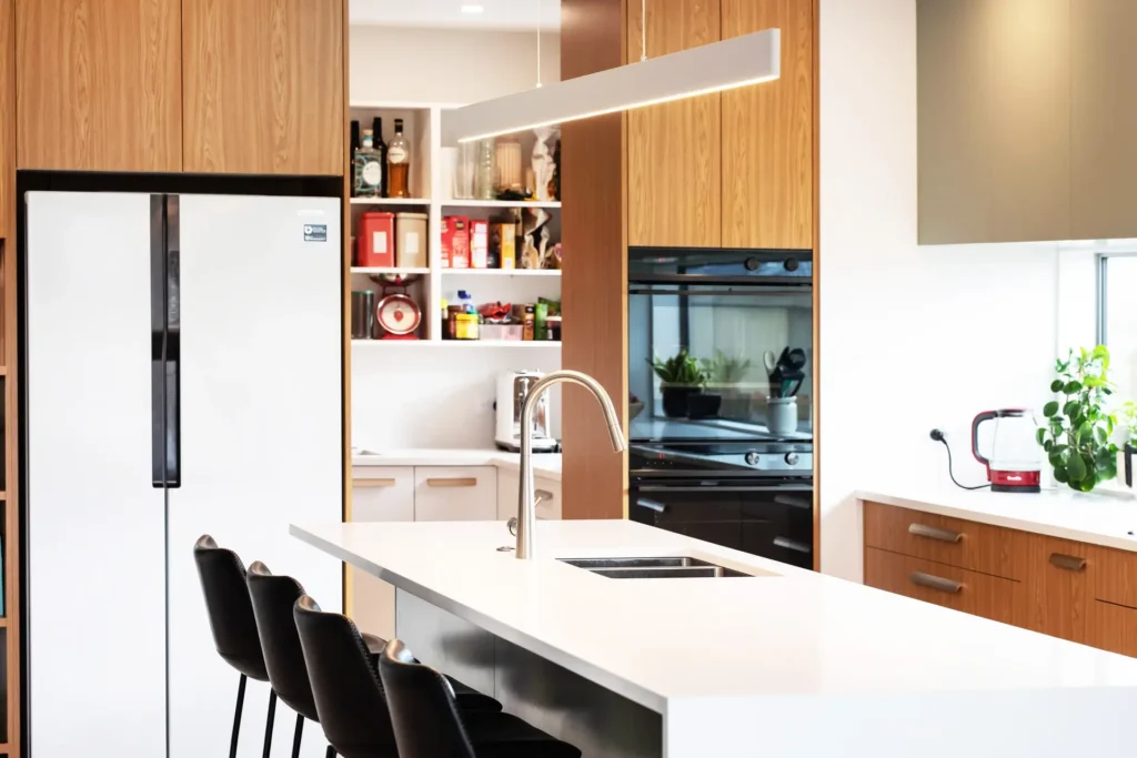 Custom kitchens Papakowhai Porirua bespoke renovation featuring contemporary cabinetry, stone benchtop and Porirua Harbour views through kitchen window